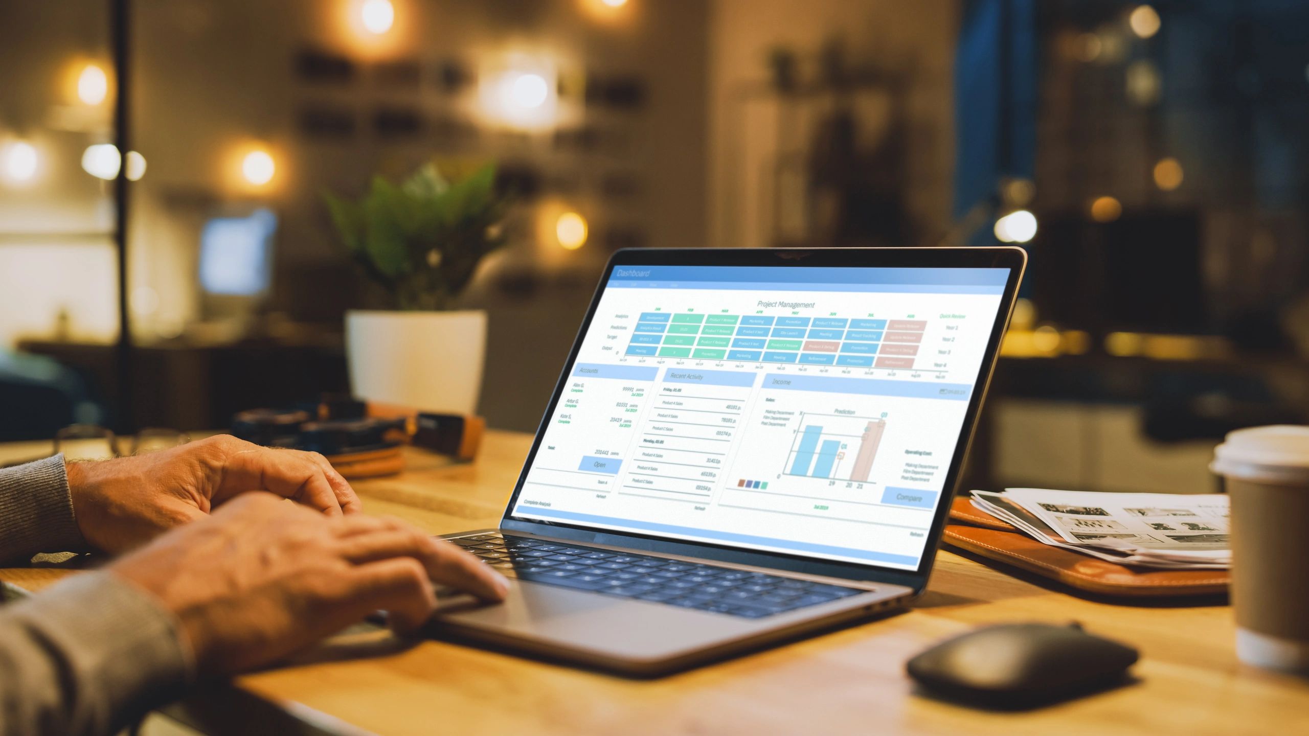 IT specialist working on a laptop with analytics on screen